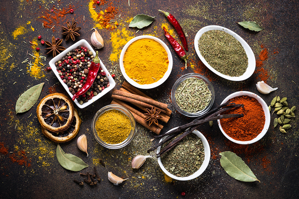 Set of Various spices and condiments on dark stone table. Chilly pepper, rosemary, basil, turmeric, paprika, garlic, anise, cinnamon and other. Top view.